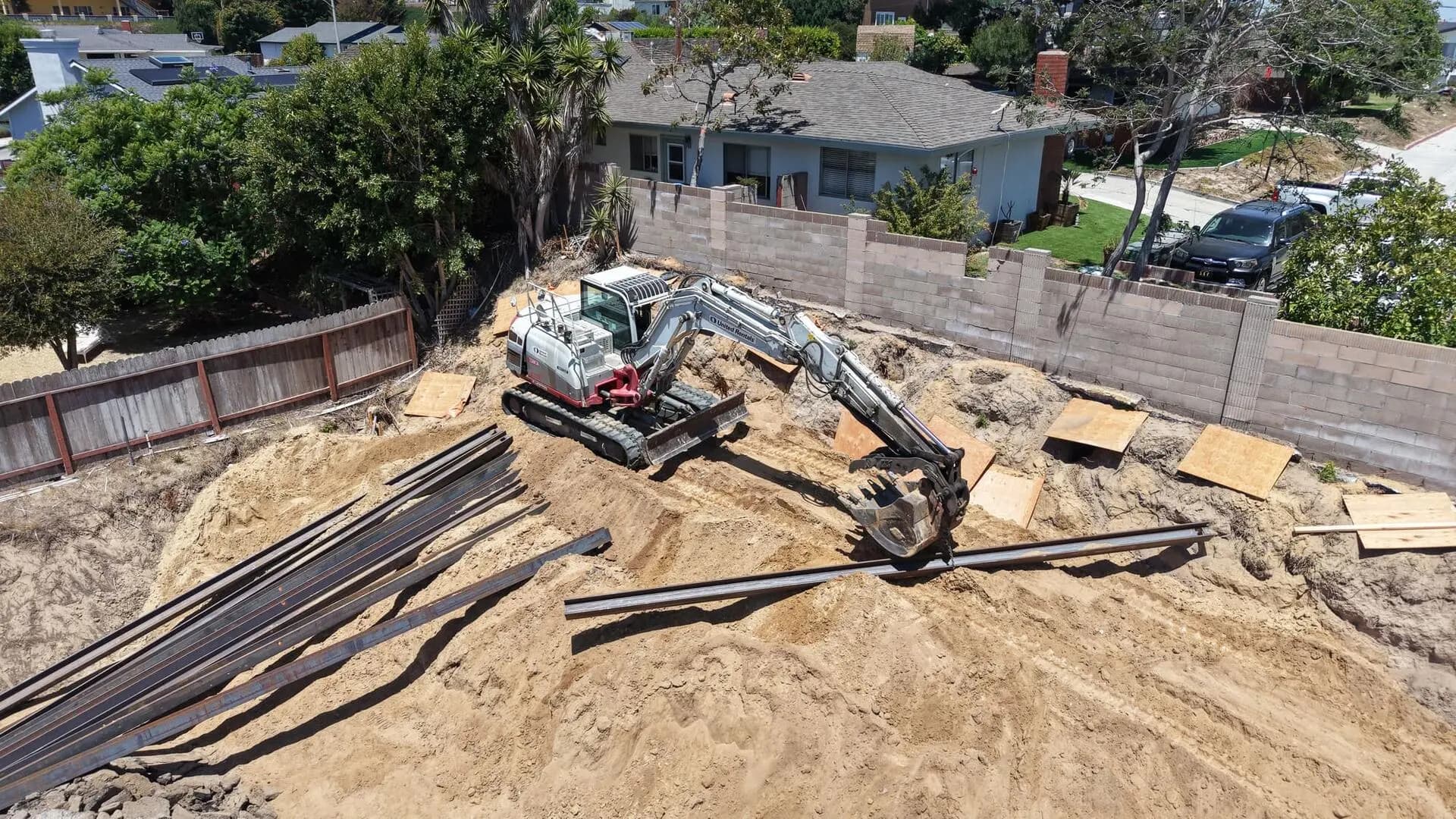 Drone view of excavation and beam placement for a caisson retaining wall system