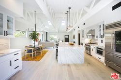 Vaulted kitchen with marble island and pendant lighting