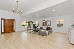 Open-concept living area with custom entry door and brass chandelier