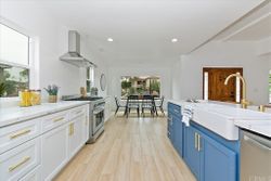 Custom kitchen with two-tone blue cabinetry and farmhouse sink