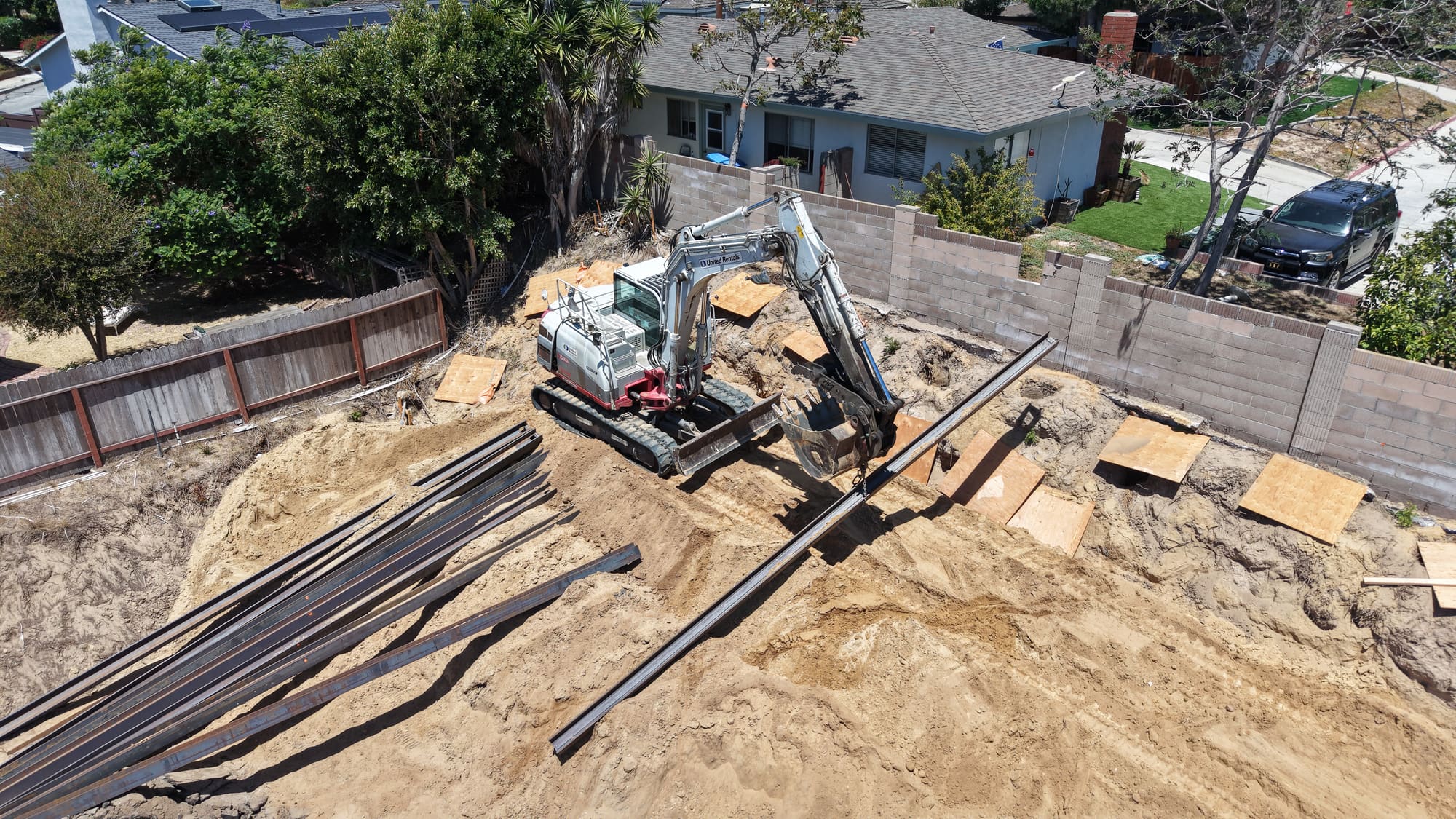 Redondo Beach caisson and I-beam retaining wall project with excavator and staged steel