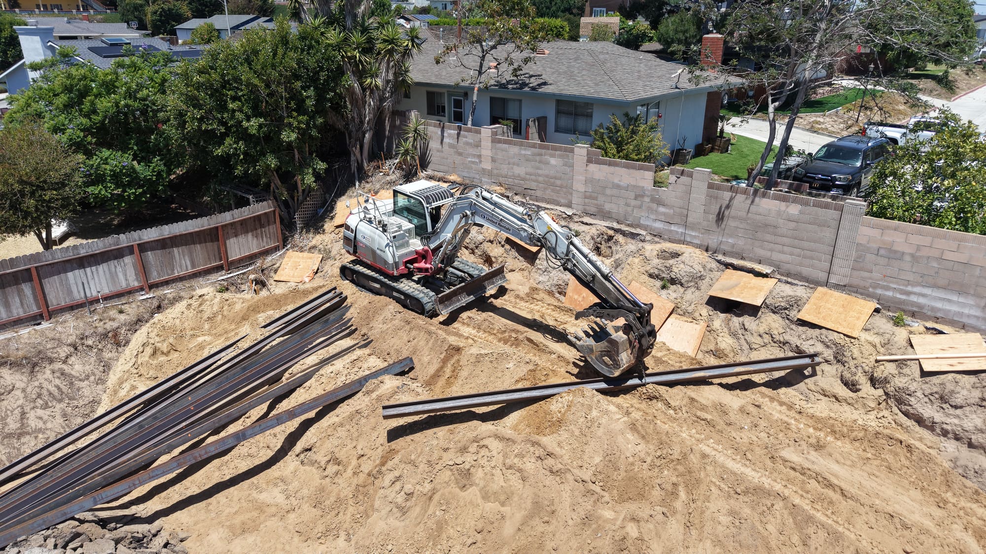 Drone view of excavation and beam placement for a caisson retaining wall system